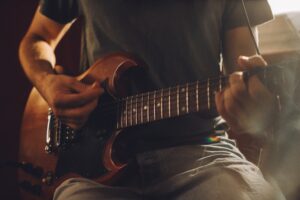 Close up of a musician playing an electric guitar during a recording session in a professional studio