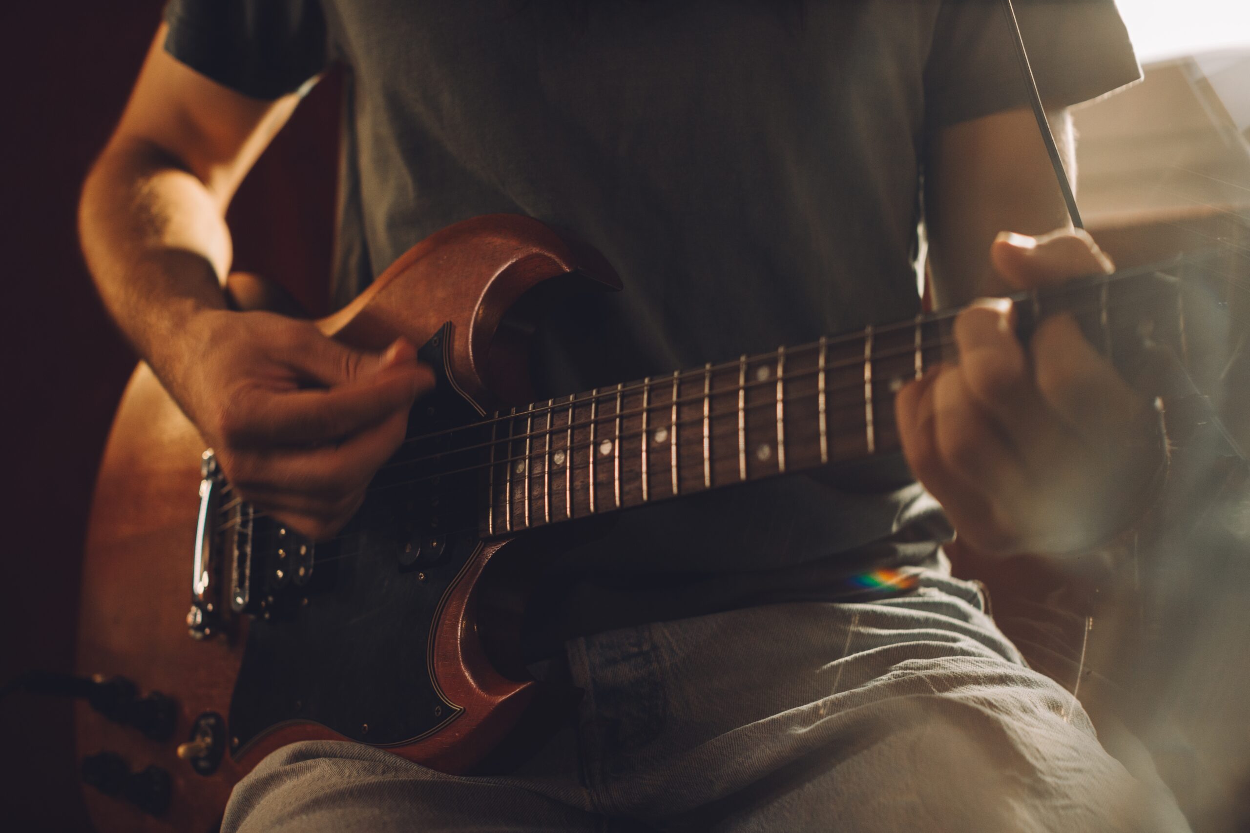 Close up of a musician playing an electric guitar during a recording session in a professional studio